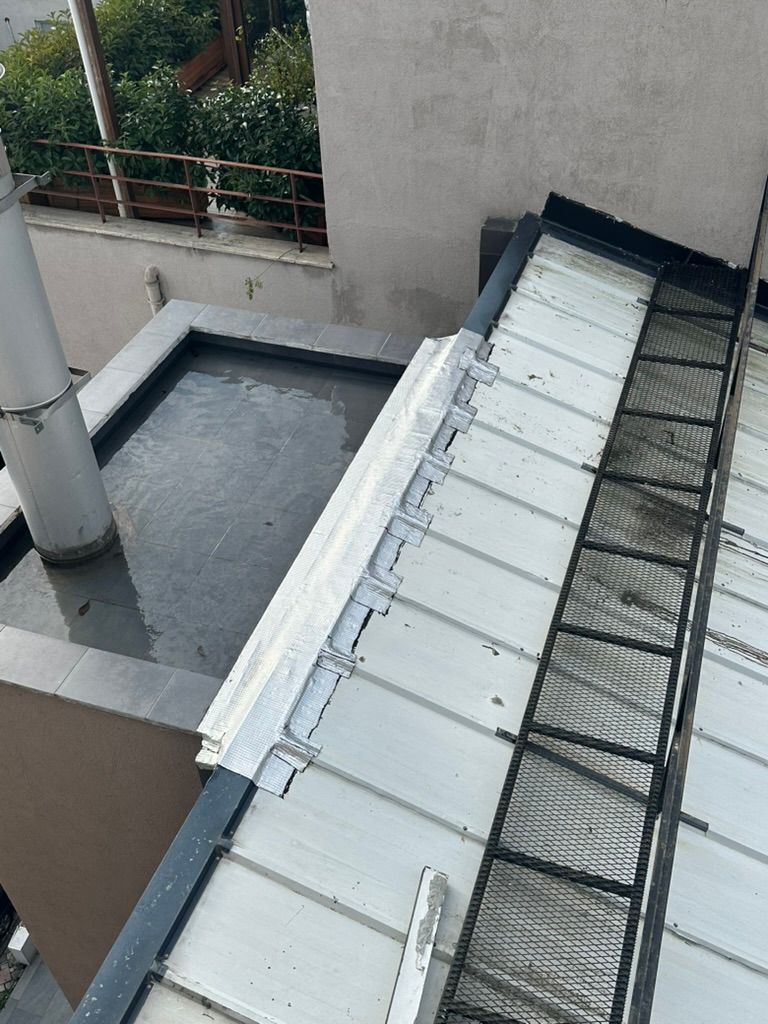 Metal çatı ile teras duvarının birleştiği yerde yapılmış izolasyon detayı.
